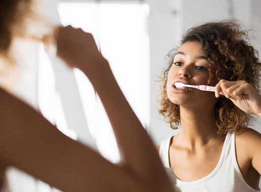 Patient in Raleigh brushing their dental implants