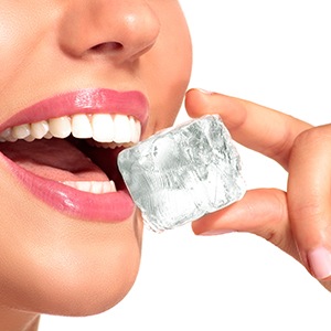 Patient in Raleigh biting ice with dental implants