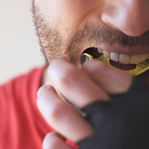 Patient in Raleigh with dental implants wearing a mouthguard