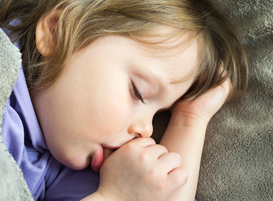 Child sleeping while sucking their thumb