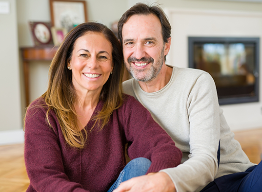 Older man and woman smiling in their living room