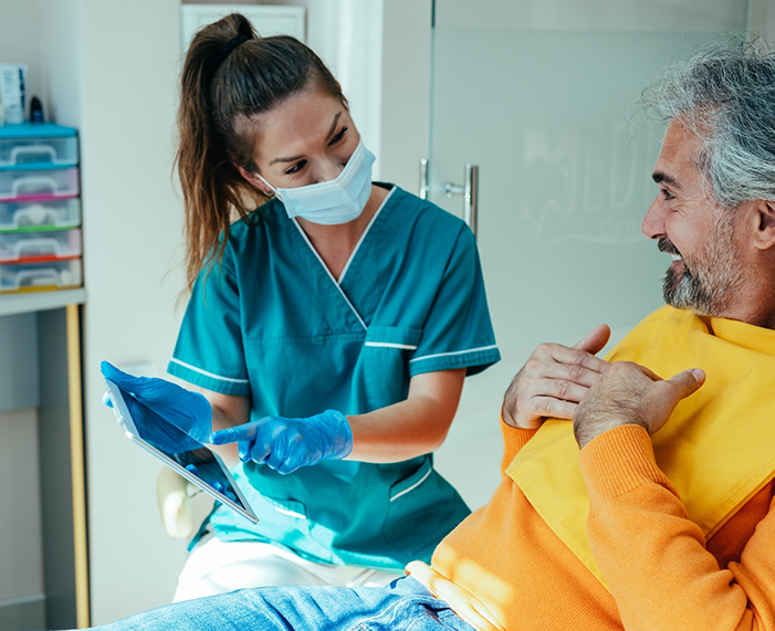 Emergency dentist in Raleigh showing a patient a tablet