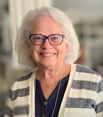 Senior woman smiling in black and white striped cardigan