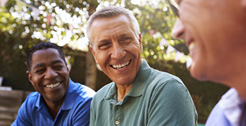 Three men laughing together outdoors