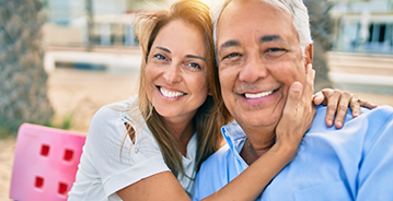 Older man and woman smiling with their faces touching