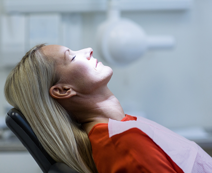 Woman relaxing in dental chair thanks to sedation dentistry in Raleigh